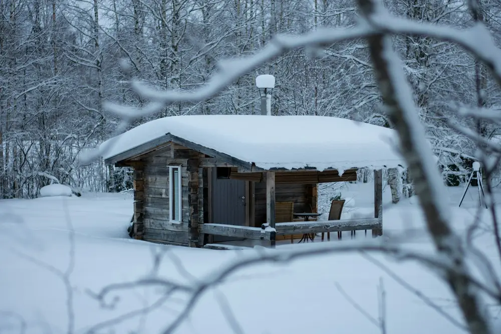 A log cabin surrounded by snow-covered trees